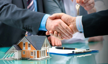 shaking hands over signer paperwork